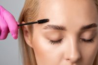 Makeup artist combs  and plucks eyebrows after dyeing in a beauty salon.Professional makeup and cosmetology skin care.